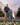 Photorealistic visualization of a father and son standing on a lawn of dandelions under a blooming cherry blossom tree. This exterior visualization showcases the green park space of a modern residential neighborhood.
