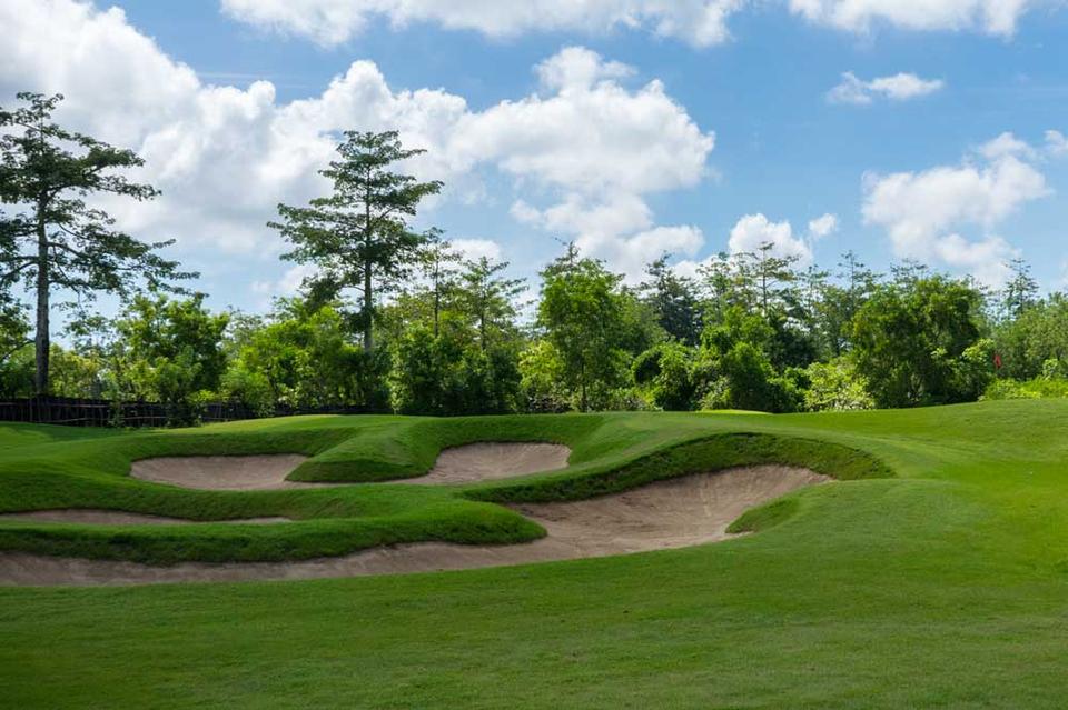 New Kuta Golf green guarded by bunkers and tropical trees