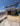 Villa construction in Sanremo, Poggio area with red brick walls, metal scaffolding, yellow safety panels, and views of Ligurian hills and coastline.