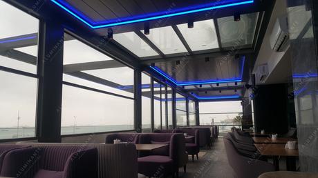 Restaurant with a wall-mounted louvered pergola and guillotine glazing