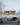 Photorealistic visualization of a modern, two-story corten steel house in a snowy winter landscape. This exterior render highlights a swan swimming in a partially frozen pond next to a wooden dock. Link to project details.
