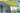 Residential terrace with extended yellow motorised retractable awning and garden views
