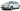 Белый седан Renault Fluence, используемый в качестве такси, на городской улице.