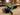 Roll of 3M double-sided foam tape on a wooden table with a blurred workshop background