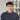 Portrait of a french International Trade student employee in a blue sweater with manufacturing equipment in the background