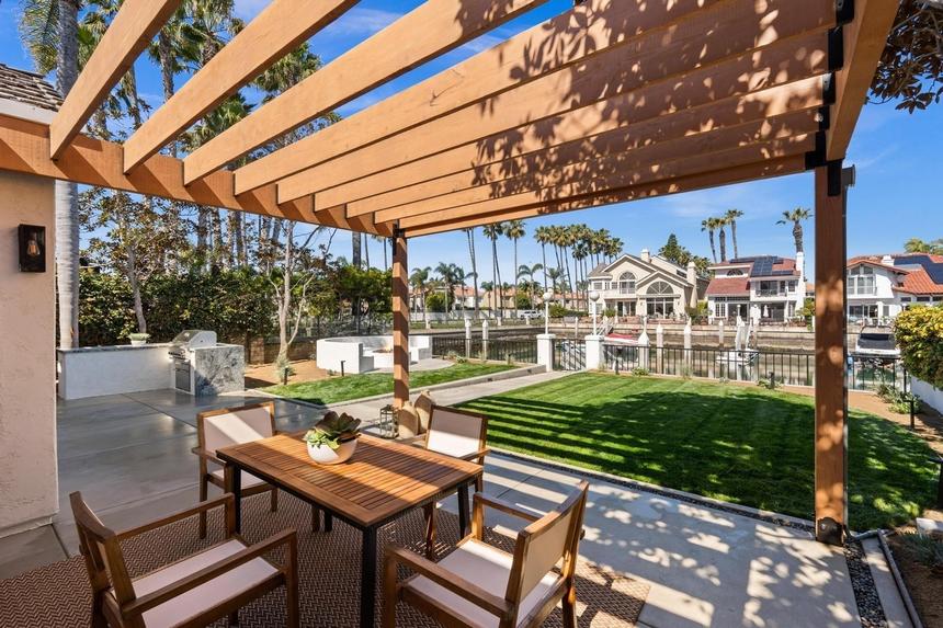 Outdoor dining under a pergola by a canal