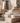 Stacked natural stone and marble materials in neutral tones for construction, and below, modern interior staircase with wooden steps, metal railings, and decorative pendant lighting in renovation project.