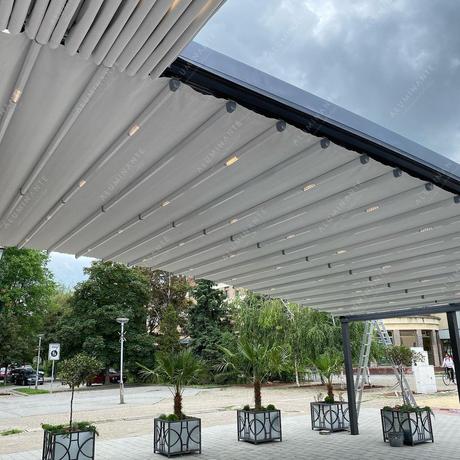Restaurant terrace under an oval retractable pergola