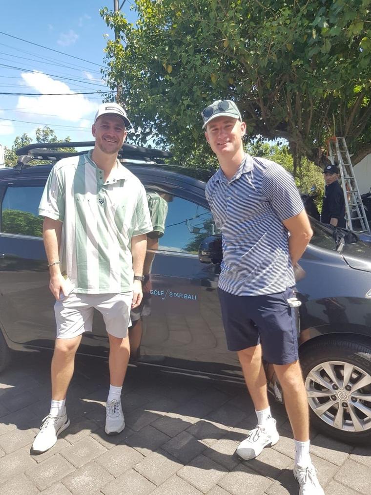 Two golfers next to their transfer car before the round