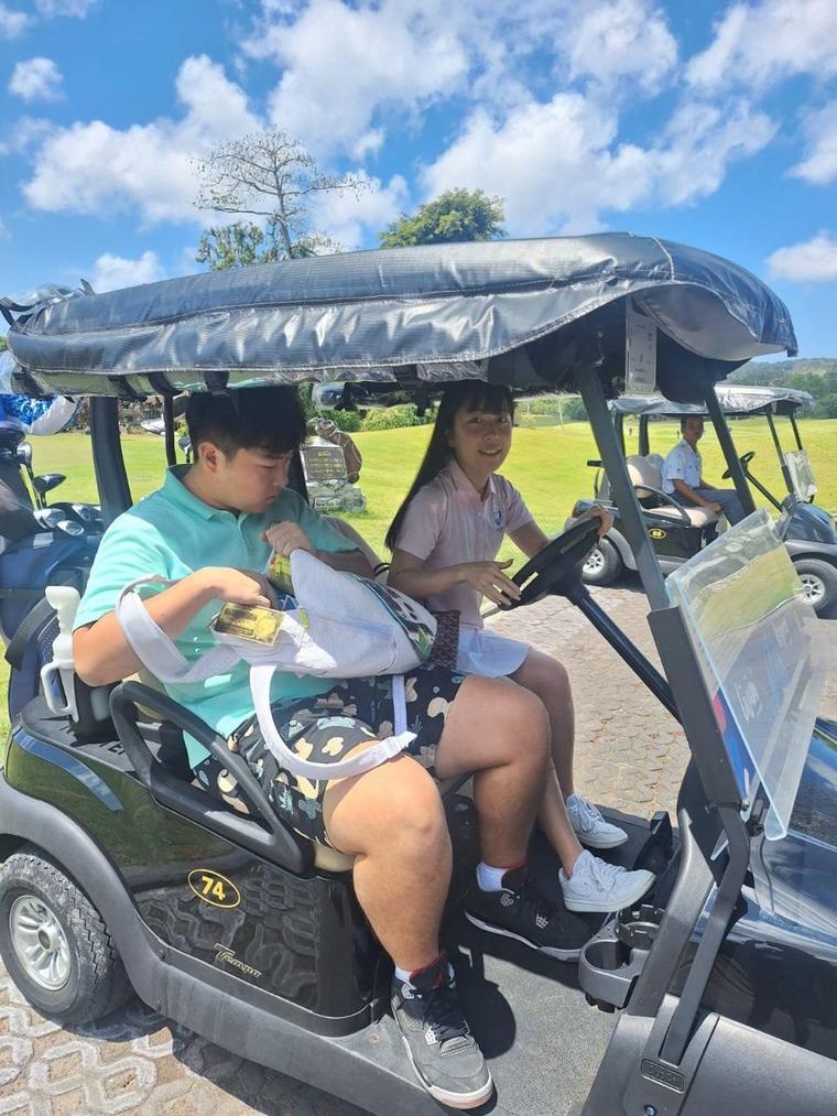 Two golfers in a golf cart on the course