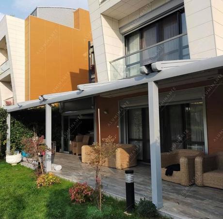 Wall-mounted retractable pergola with guillotine glazing