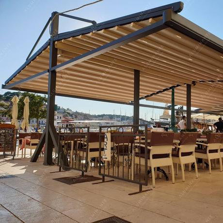 Café summer patio with a freestanding dual-pitched retractable pergola