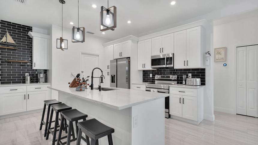 White kitchen with an island in a rental home