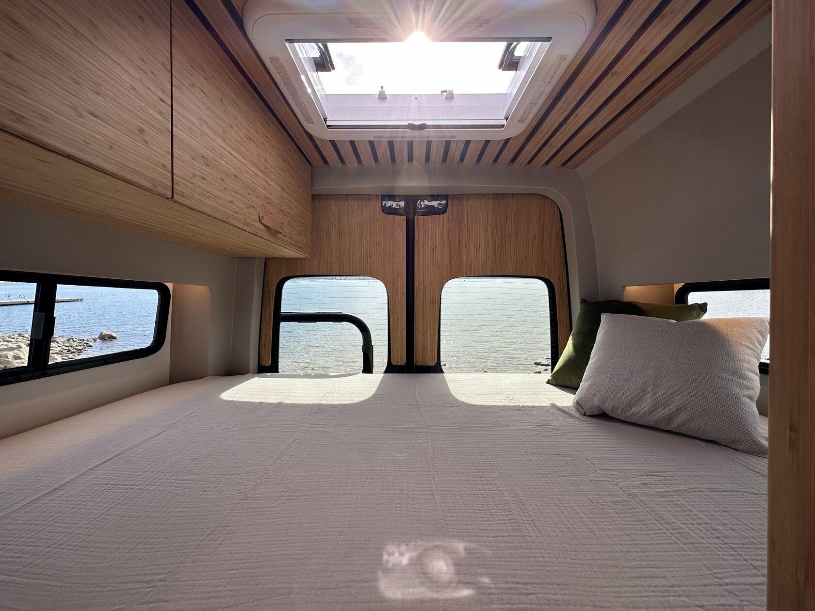 Aura permanent bed under a skylight with a view of the water