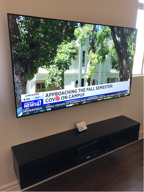 Living room cinema with concealed screen above the fireplace