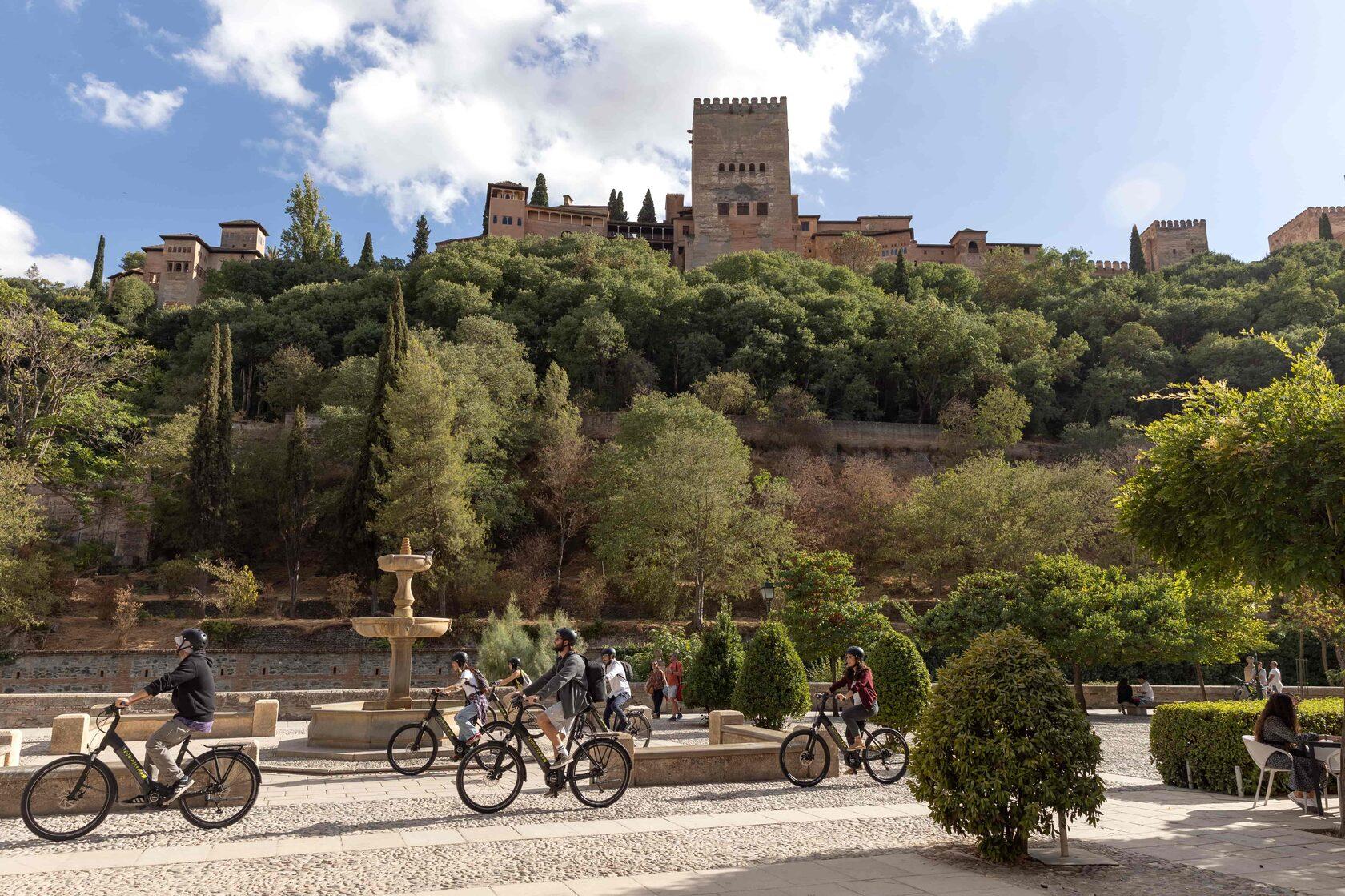Small group on electric bikes riding below the Alhambra in Granada