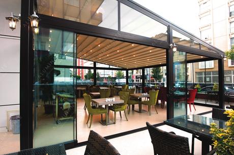 Restaurant with a wall-mounted retractable pergola and ORIZZONTE glazing