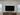TV above a wooden console between two windows