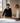 Two professionals reviewing architectural plans and technical drawings on table with natural window light, coordinating building design and construction documentation for Liguria property projects.