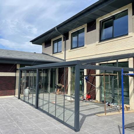 Glass-enclosed terrace with a PRADA roof and frameless glazing